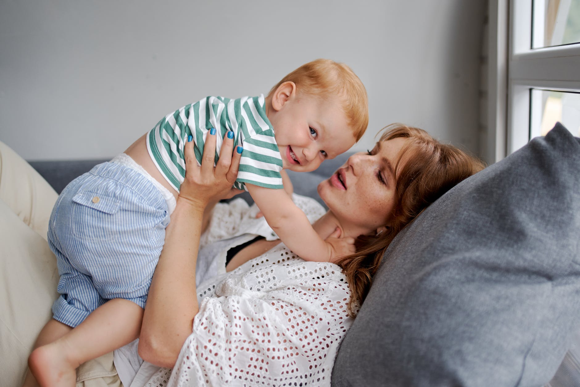 mother with happy little boy resting on couch